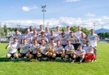 Neue Gesichter, neue Wege: Die 4. Liga startet in sechs Gruppen Group of soccer players in white jerseys posing for a victory photo on a sunny field, holding a trophy.