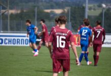 Sieg nach Aufholjagd: Perlen-Buchrain dreht Testspiel gegen Cham II Soccer players on a field, maroon team with number 16 foreground watching a game against blue team in the background