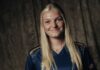 FCL: Romy Baraniak stösst zum AWSL-Team Smiling young woman with long blonde hair wearing a navy sports jersey, standing against a dark textured backdrop.
