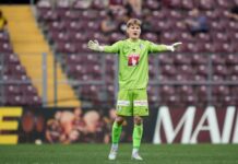 Severin Ottiger und Pascal Loretz verlassen den FC Luzern Soccer goalkeeper in neon green kit stands with arms outstretched on the pitch during a match.