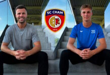 Cham verstärkt sich weiter Two athletes sit on concrete stadium steps with hands clasped, SC Cham crest centered between them behind.