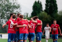 Tia schiesst Cham zum Auftaktsieg Soccer players in red jerseys huddle together on a green field before a game.