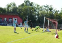FC Schötz: Nicht gegebenes 1:1 sorgt für Diskussionen Soccer match scene: players in light-blue jerseys near the goal as the goalkeeper in neon yellow dives to reach the ball by the net.