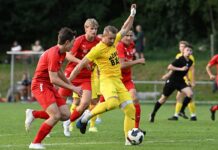 Altdorf überzeugt im Cup und blickt auf die neue Saison Yellow-shirted soccer player controls the ball while red-clad opponents close in on a grassy field.