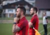 FC Grosswangen-Ettiswil: Übersicht Zu- und Abgänge und Spielvorschau Two men in red soccer jerseys stand on a field; foreground man with hand on chin and tattooed arm.