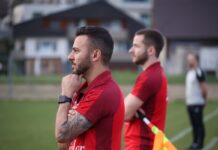 FC Grosswangen-Ettiswil: Übersicht Zu- und Abgänge und Spielvorschau Two men in red soccer jerseys stand on a field; foreground man with hand on chin and tattooed arm.