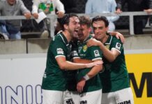 Kriens übersteht schwierige Startphase und schlägt Nyon klar Three soccer teammates in green jerseys celebrate a goal together on the field, arms around each other, smiles on their faces in front of a stadium crowd.