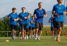 SC Cham II: Mit vielen jungen Spielern in die neue Saison Group of male soccer players in blue jerseys running on a grassy training field.
