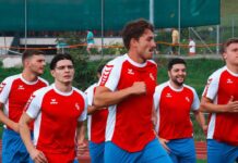 Küssnacht startet mit Krimi gegen OG in die 2. Liga A group of young men in red and white soccer jerseys jogging together on a track field.