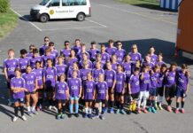 JuniorInnenlager FC Baar: Eine Woche voller Leidenschaft, Schweiss und Gemeinschaft Group of children and teens in purple CSS jerseys posing for a team photo in a parking lot beside a white van with a club logo.