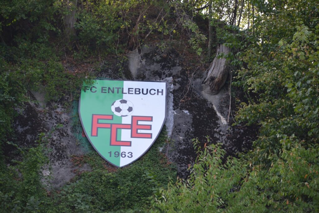FC Entlebuch football club crest on a mossy rock wall with a soccer ball and 1963.