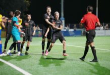 Schötz kämpft bis zum Schluss, steht aber mit leeren Händen da Soccer players in black uniforms celebrate a goal on a bright green field at night, with a referee in red nearby.