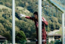 FCL: Jérôme Bieler unterschreibt Profivertrag Soccer goalkeeper in a maroon kit and gloves stands behind a goal, one gloved arm extended as she points toward the field.