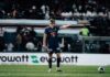 Frühe Rote Karte und erneute Fehler bestrafen den FCL gnadenlos Soccer player in a dark blue kit and protective mask gestures with one arm on a green field, with a blurred crowd behind and a ball to the right.